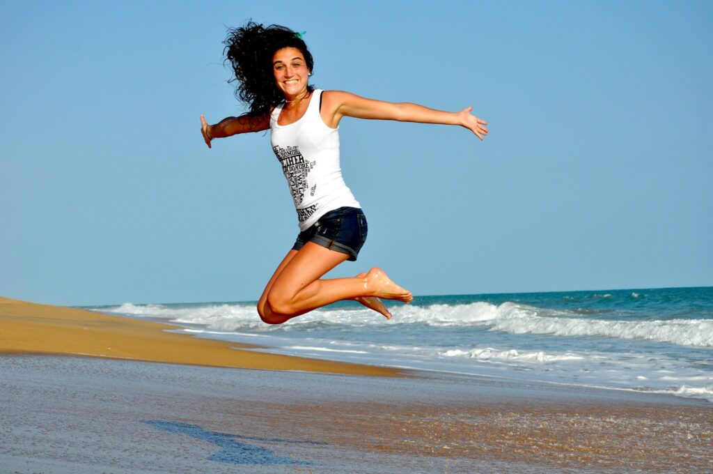 Hoppende kvinde på strand